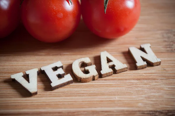 Concepto palabra que forma con letra de madera y tomates — Foto de Stock