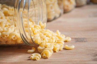 ahşap kesme tahtası üzerinde Cam kaplarda çeşitli makarna