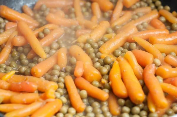 Pois verts et carottes dans le poêle — Photo