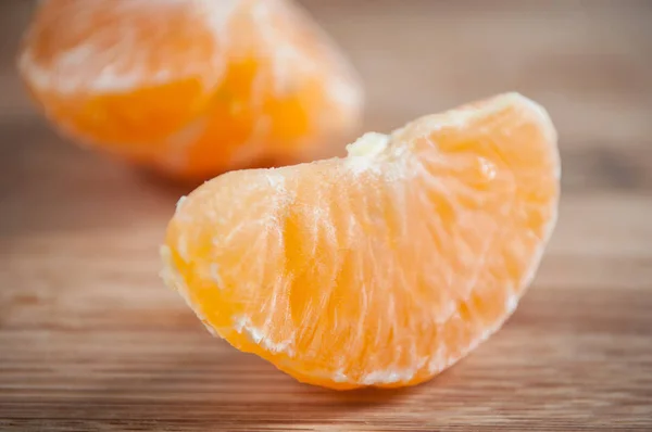 Mandarina pelada sobre fondo de tabla de cortar de madera — Foto de Stock