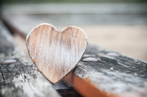 Dřevěné srdce na lavičce v přírodě - Love koncepce — Stock fotografie