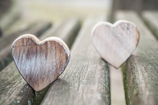 Corações de madeira no banco ao ar livre - Conceito de amor — Fotografia de Stock