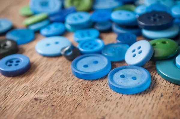 Botones de costura azul sobre fondo de madera — Foto de Stock