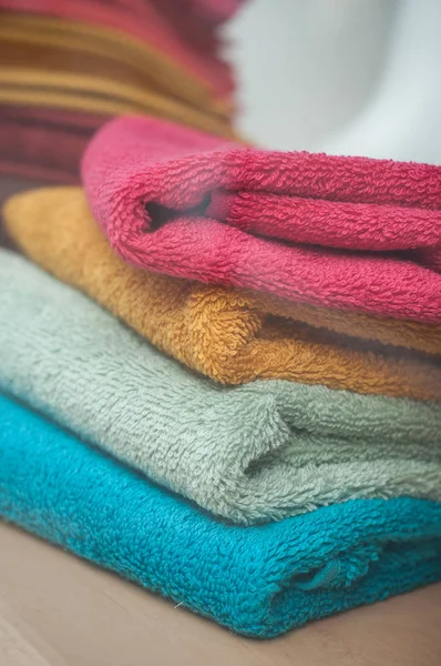 Färgglada handdukar högen i butik — Stockfoto