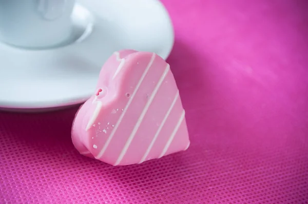 Pink shaped heart pastry and cup of coffee — Stock Photo, Image