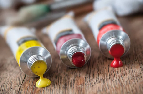 Tinta acrílica em tubo sobre fundo mesa de madeira — Fotografia de Stock