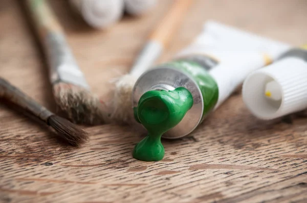 Tinta acrílica verde sobre fundo mesa de madeira — Fotografia de Stock