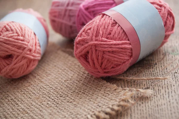 Bolas de lana rosa sobre fondo de mesa de madera — Foto de Stock