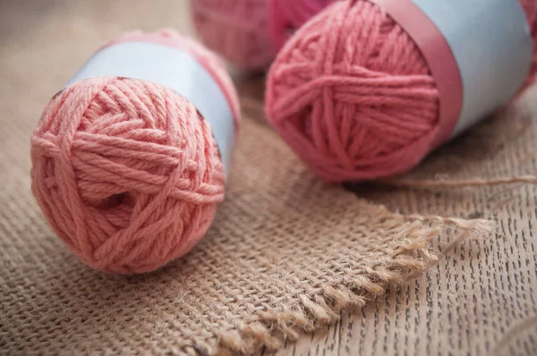 pink wool balls on wooden table background