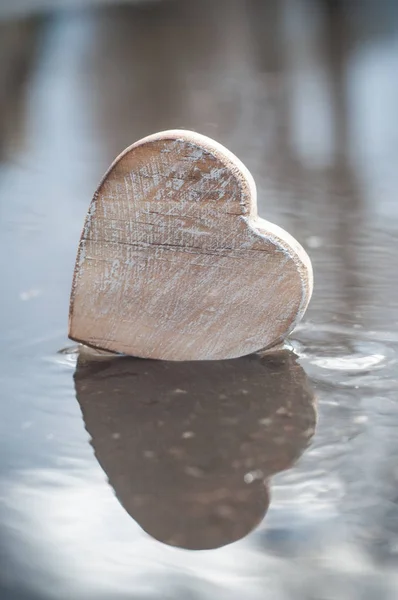 reflection in a puddle of wooden heart - Love concept