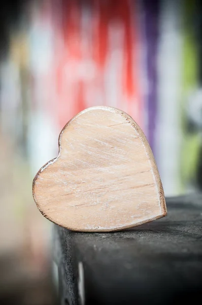 Дерев'яне серце на відкритому повітрі на розмитій графіті стіні — стокове фото