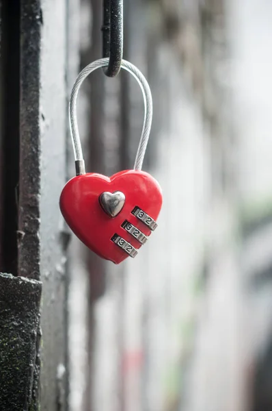 Cadenas rouge en forme de coeur sur grille métallique — Photo