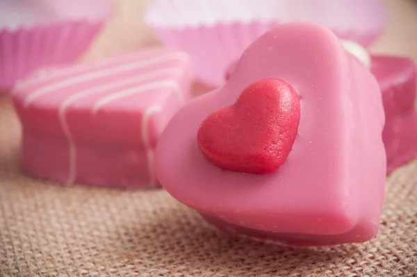 Pastelería corazón en forma de rosa sobre fondo de textura hessiana — Foto de Stock