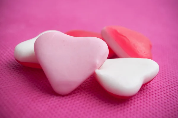 Форми серця цукерки на рожевому фоні — стокове фото