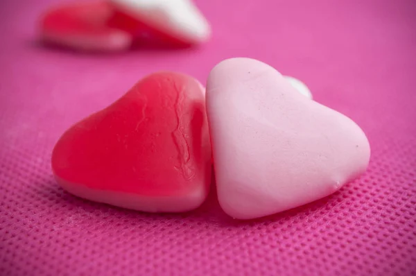Форми серця цукерки на рожевому фоні — стокове фото
