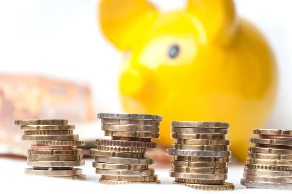 Euro coins piles and bank notes with yellow piggy bank — Stock Photo, Image