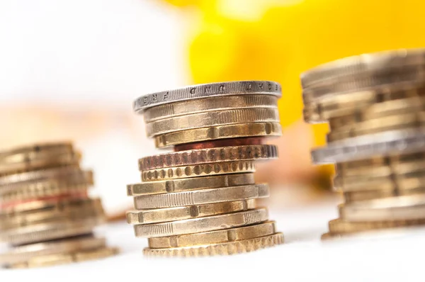 Euro coins piles and bank notes with yellow piggy bank — Stock Photo, Image