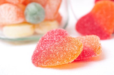 şeffaf cam kapsayıcıdan düşen şekilli kalp şekerler