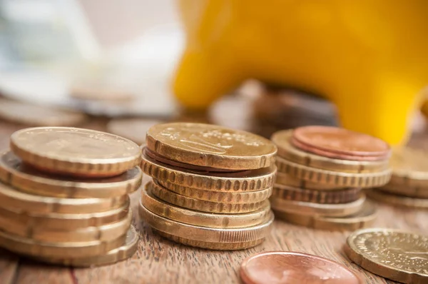 Banco piggy amarelo em moedas de euro e notas de banco — Fotografia de Stock