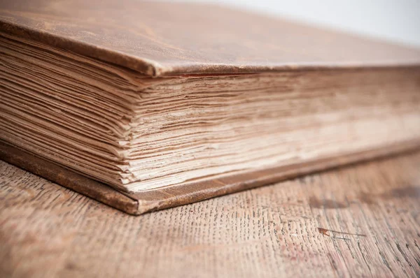 Starożytna Księga ZAMKNIĘTA na tle drewniany stół — Zdjęcie stockowe