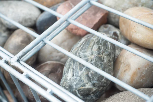 Red de cesta metálica llena de adoquines naturales como una cerca de gaviones — Foto de Stock