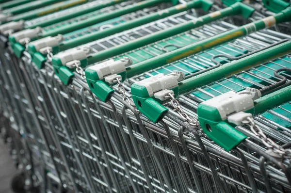 Zielony supermarket wózki wyrównanie — Zdjęcie stockowe