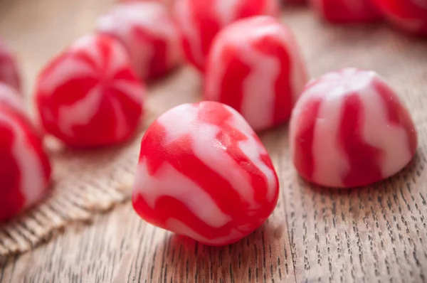 Tradiční červené a bílé bonbony na dřevěné pozadí — Stock fotografie