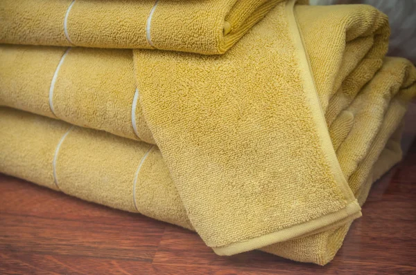 Pila de toallas de baño amarillas en sala de exposición dolorida — Foto de Stock