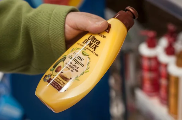 Бутылка шампуня от бренда Гарнье в руке в супермаркете Super U — стоковое фото