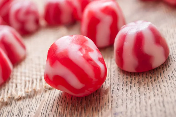 Caramelos rojos y blancos tradicionales sobre fondo de madera —  Fotos de Stock