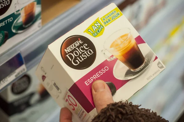 Крупный план капсул доз кофе в руке от Dolce gusto бренда компании Nestle в супермаркете Cora — стоковое фото