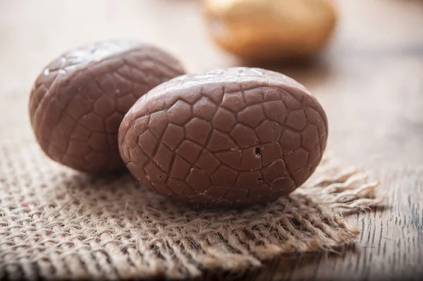Шоколадні великодні яйця на дерев'яному фоні столу — стокове фото