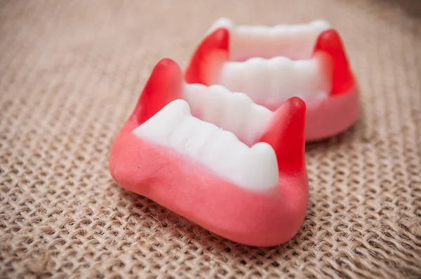Caramelos tradicionales en forma de dientes sobre fondo hessiano —  Fotos de Stock