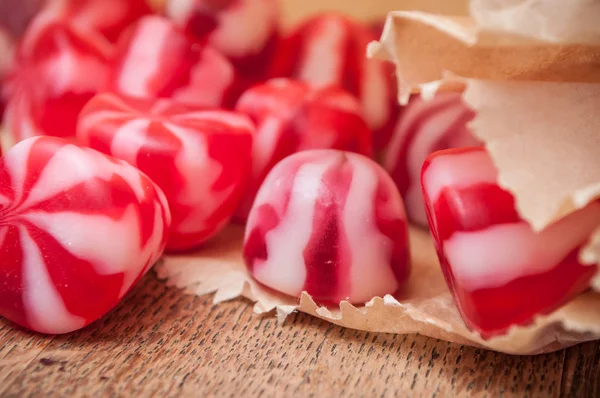 Caramelos rojos y blancos tradicionales sobre fondo de madera —  Fotos de Stock