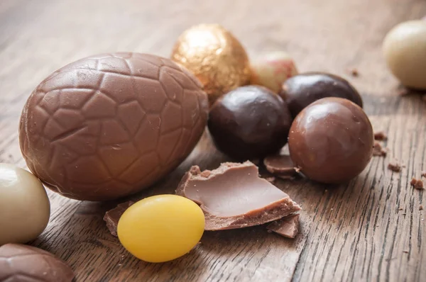 Різні шоколадні великодні яйця на дерев'яному фоні — стокове фото