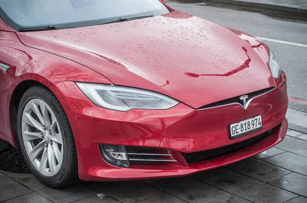 Красный автомобиль Тесла припаркован на улице к дождливому дню — стоковое фото