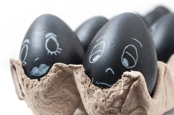Schwarze lustige Ostereier mit ausdrucksstarkem Gesicht in Kreide gezeichnet — Stockfoto