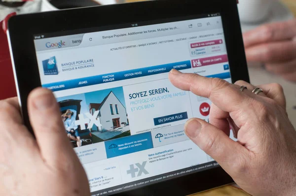 Close-up van vrouw handen op de banque populaire Franse bank home page van de website op Tablet PC — Stockfoto