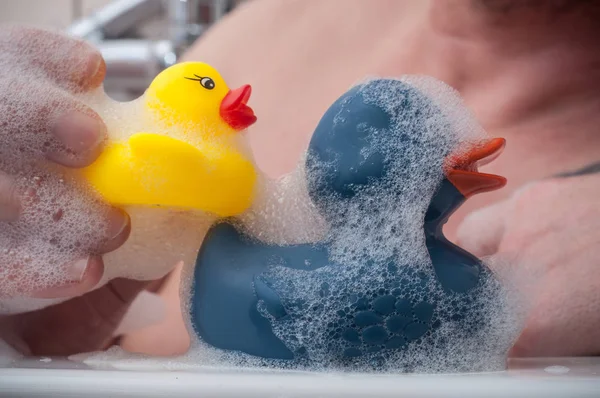 Banyo üzerinde lastik ördek oyuncaklarla oynayan adam — Stok fotoğraf