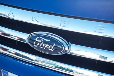  Mavi bir araba Ford logosu. chromes üzerinde yansıması ile. Dearborn, Michigan merkezi bir Amerikan çokuluslu otomobil üreticisi Ford Motor Company olduğunu.