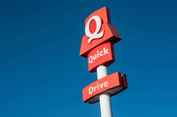 Snelle fastfood-logo op een paal op blauwe hemelachtergrond. Quick is een Belgische fast-food keten, die werd in 1980 opgericht in Frankrijk. — Stockfoto