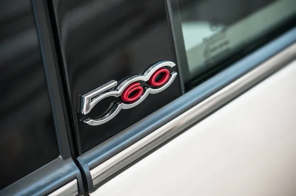 Detailhandel voor Fiat 500 logo op parelwitte beige auto geparkeerd in de straat — Stockfoto