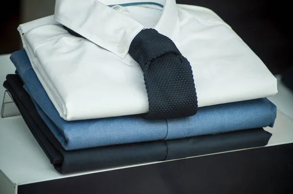 Camisas y pila de corbata en un showroom tienda de moda — Foto de Stock