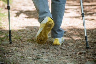 spor ayakkabı ve trekking içinde sopa ile üst düzey kadın ayakları
