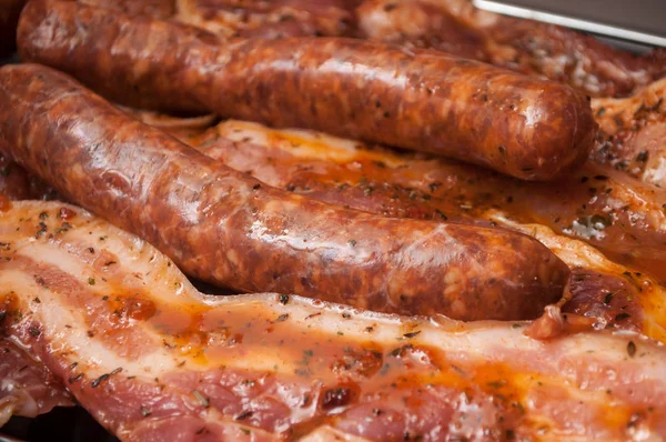 Saucisses et poitrine de porc sur le barbecue — Photo