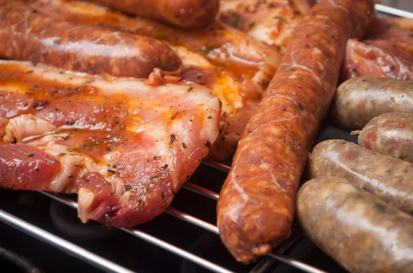 Saucisses et poitrine de porc sur le barbecue — Photo