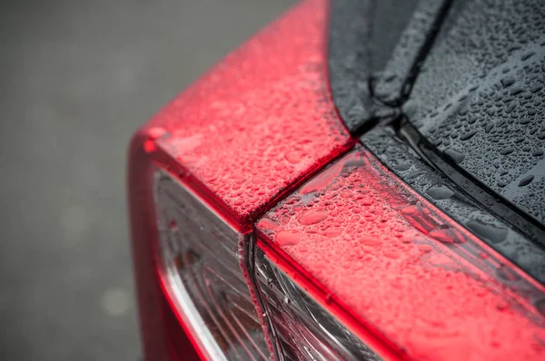 Gotas de lluvia luces traseras de encendido coche negro — Foto de Stock