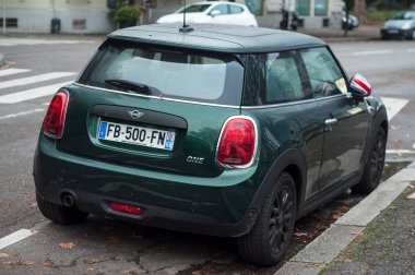 Yeşil mini Cooper 'ın arka manzarası sokağa park edilmiş. 