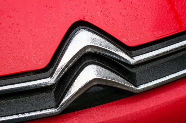 길에 주차되어 있는 빨간 자동차 앞에 있는 시트로 엔 로고에 빗방울을 떨어뜨린다 — 스톡 사진