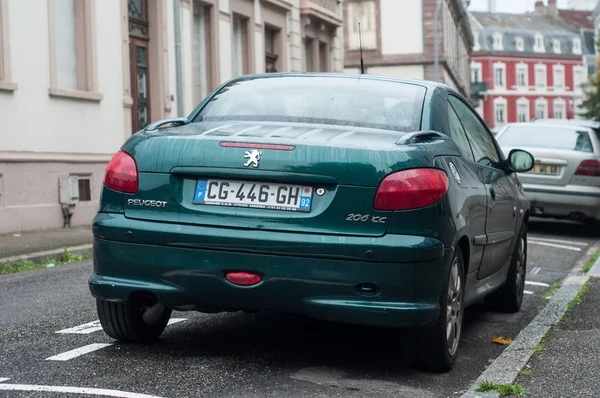 Rear view of green peugeot 206 cc parked in the street by rainy day — Φωτογραφία Αρχείου